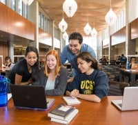 Students sitting around computer in upper paseo