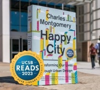 A Happy City Book in front of the library with the UCSB Reads logo