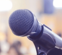 image of a microphone with a blurry audience in the background