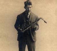 Rudy Vallee holding a saxophone.