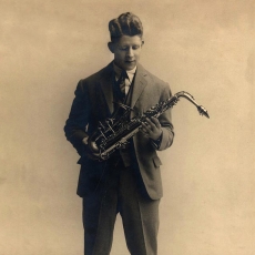 Rudy Vallee holding a saxophone.