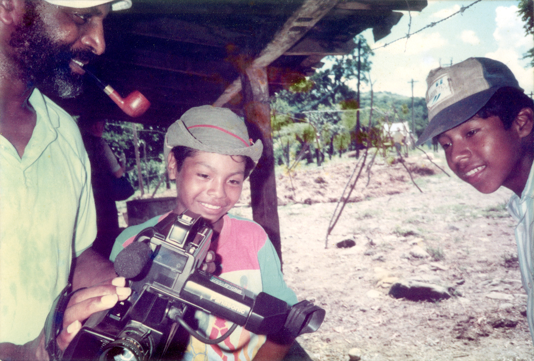 Cedric Robinson shows two children how to use a video camera in Nicaragua in the late 1980s