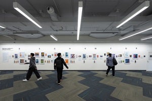 While passing by the Ocean Gallery, two students pause to view the Creating Community Through Books exhibition.